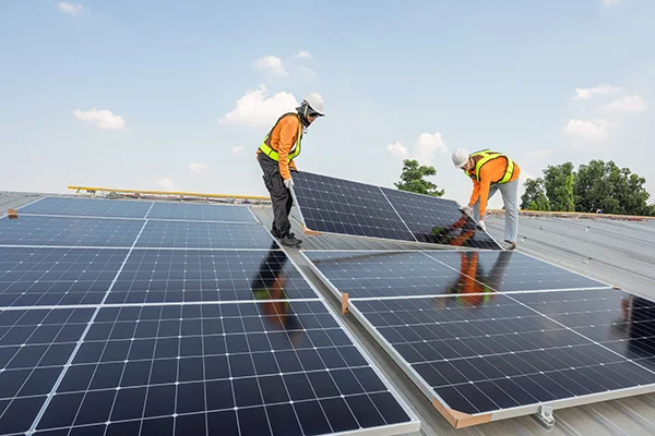 Zwei Mitarbeitende von Brücken Energie aus Euskirchen installieren Photovoltaik Paneele auf einem Privathaus